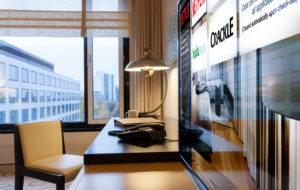 Hotel room with writing desk and TV displaying Enseo's interface