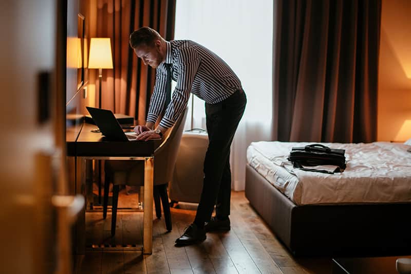 Businessman working from hotel. Executive manager on his laptop in hotel room.