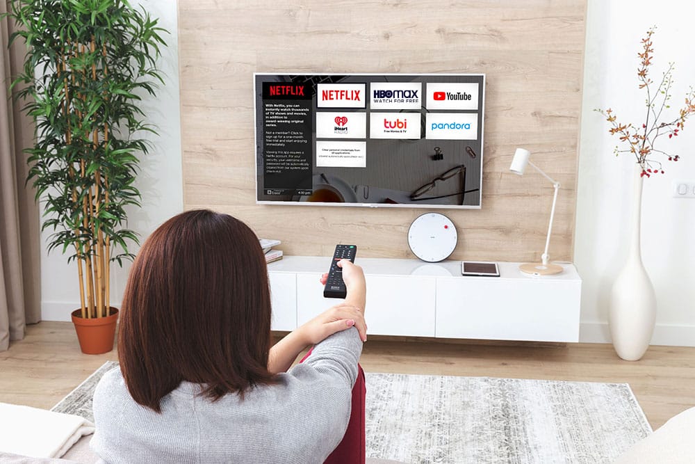 Young woman watching Streaming Apps on the TV with Enseo In-Room Entertainment
